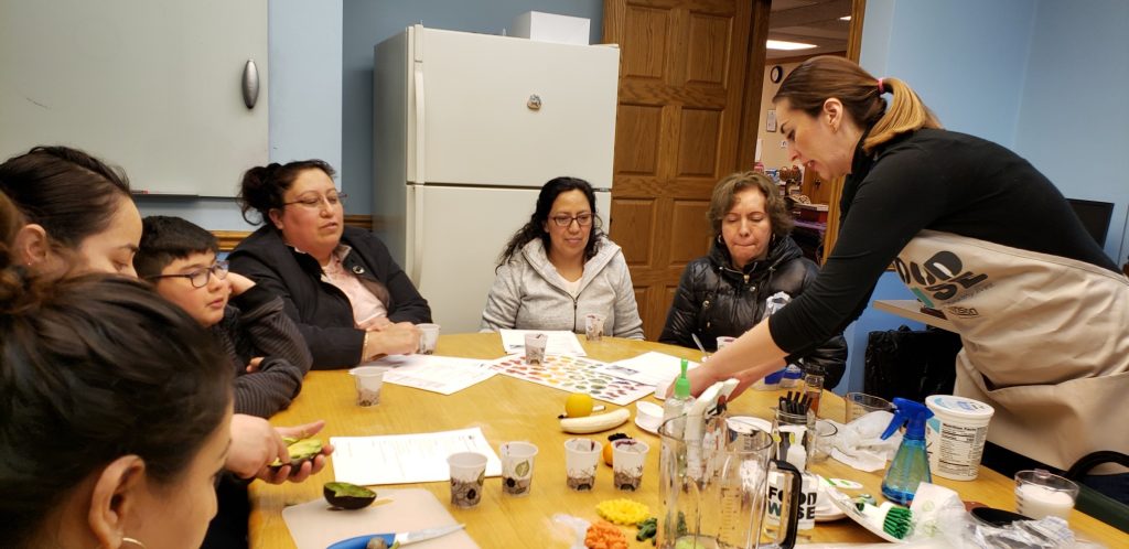 Spanish bilingual nutrition education with people sitting at a table.