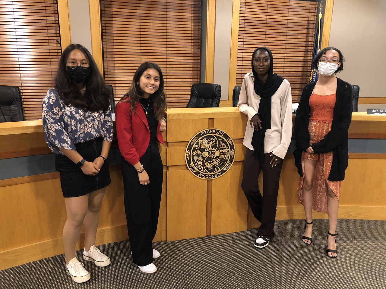 Four young people posing at a government office.