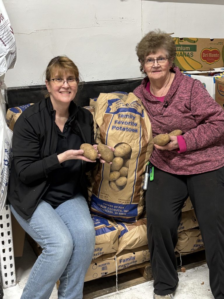 Tracy Bruce-Minehan and a Peters Pantry volunteer with potatoes from Alsum Farms