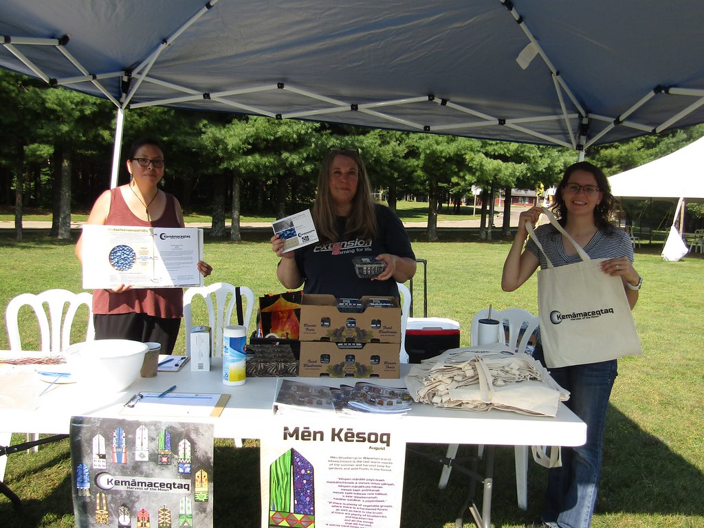 Three Extension colleagues sharing Harvest of the Moon resources at the farmers' market.