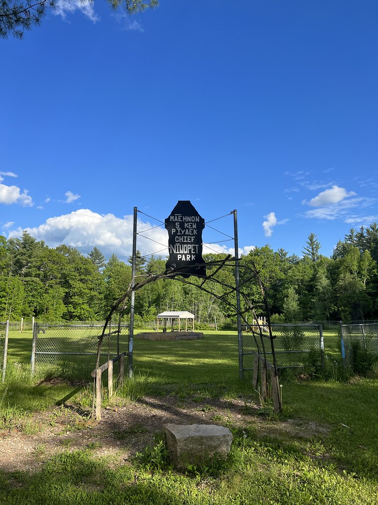 Picture of a park with a sign and blue sky.
