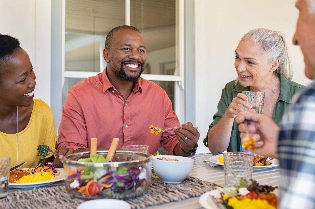 Adults sitting at a dinner table smiling and talking with each other